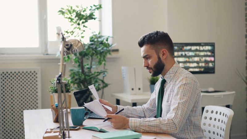 Professional reviewing plan documents at desk